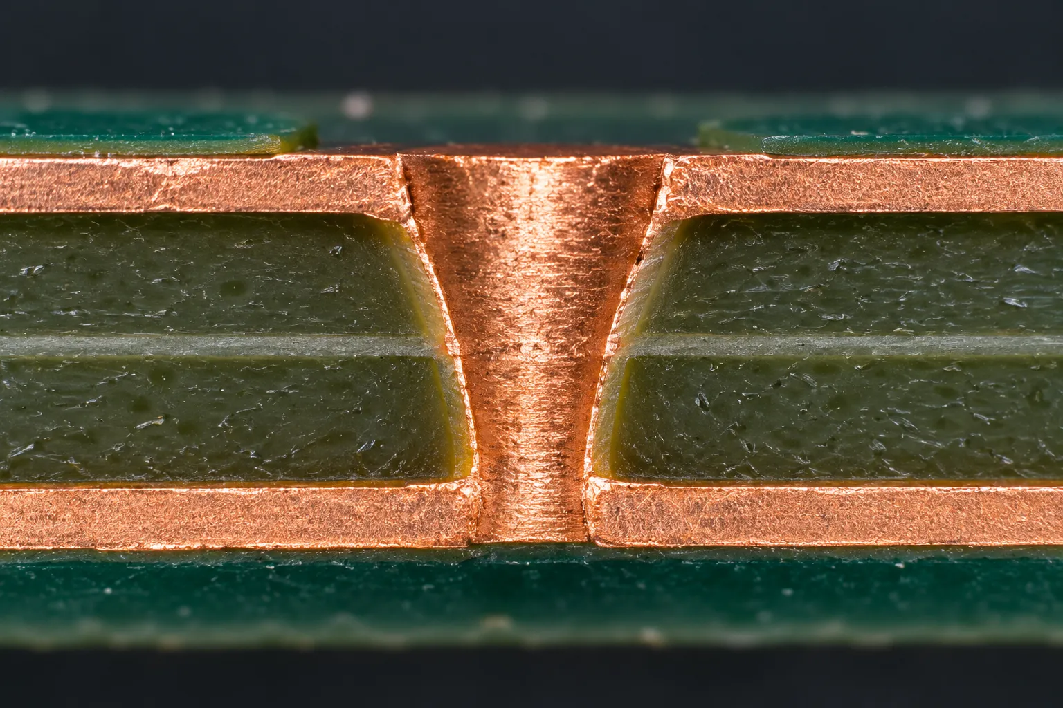 Cross-section of a copper-filled laser-drilled microvia connecting two copper layers